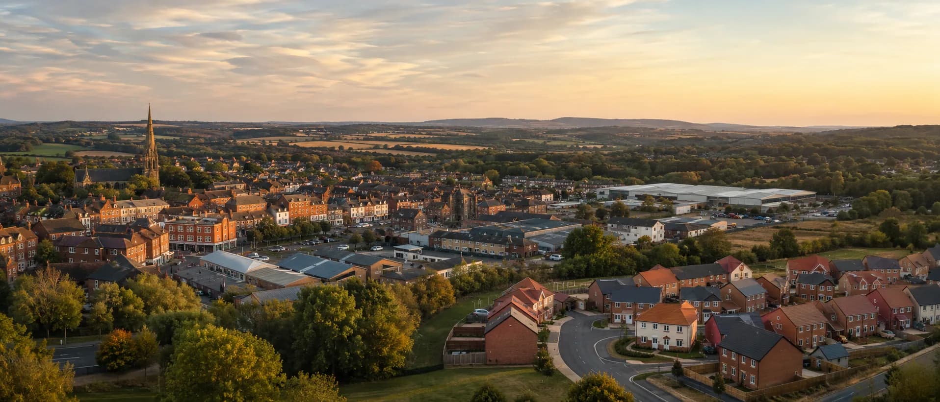 A British market town high street of brick commercial buildings at golden hour